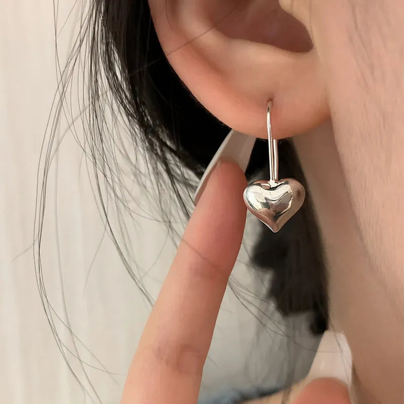 Heart-shaped copper earrings with white gold plating and glossy finish, showing three-dimensional design