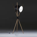 Modern three fork floor lamp with wood body and white acrylic shade on a wooden floor.