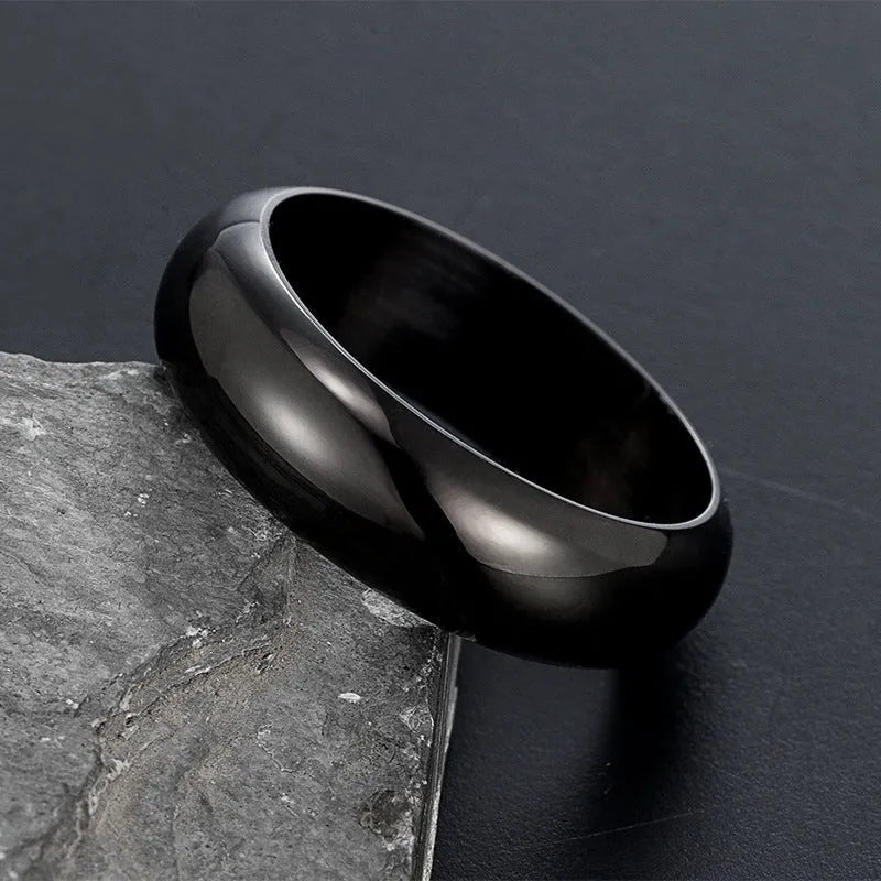 Glossy electroplated titanium steel ring in gold, black, and steel colour options on a grey background