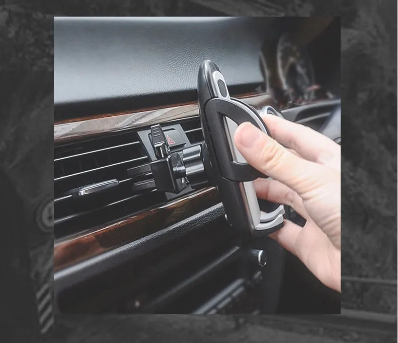Black plastic mobile phone holder attached to car air conditioning vent with phone secured