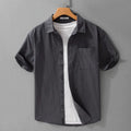 Men's light blue loose-fit short sleeve cotton shirt on a hanger.