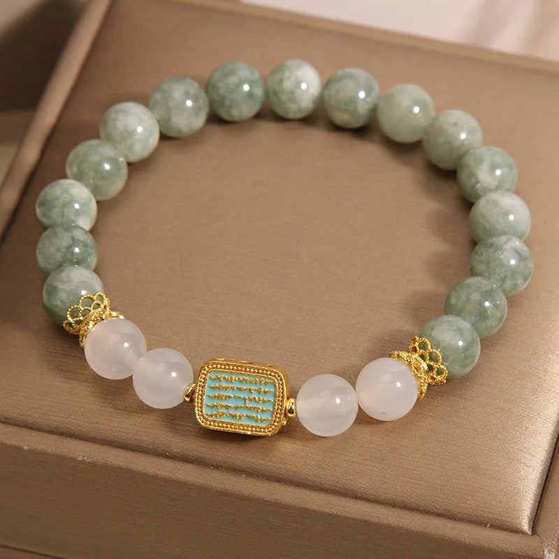 Natural oil green emerald crystal bracelet with five beads on a black elastic cord.