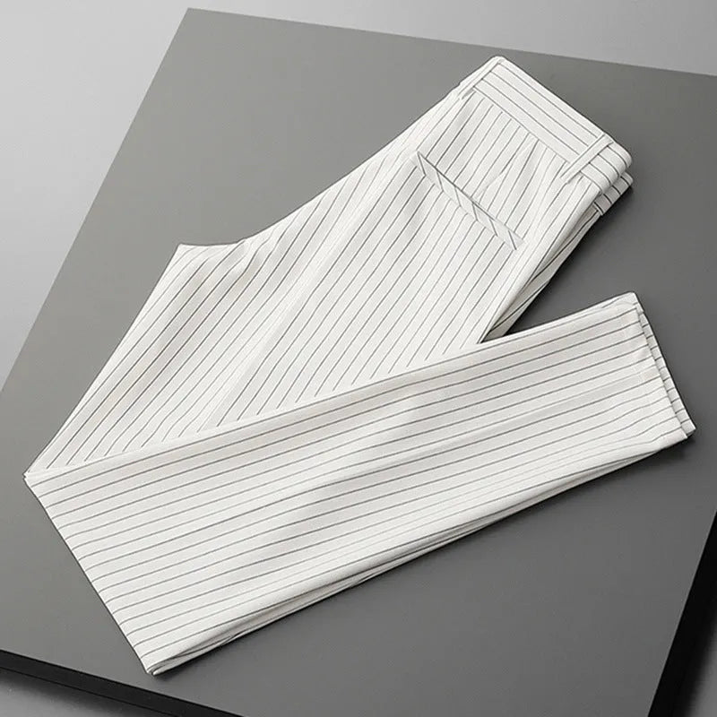 Man wearing loose fit thin striped suit pants in a crop jeans style, available in black or white.