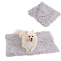 Light grey velvet pet blanket folded on a sofa next to a sleeping dog.
