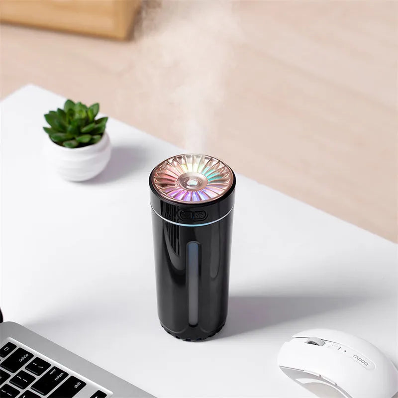 Black portable USB rechargeable humidifier with colourful LED lights on a car cup holder.