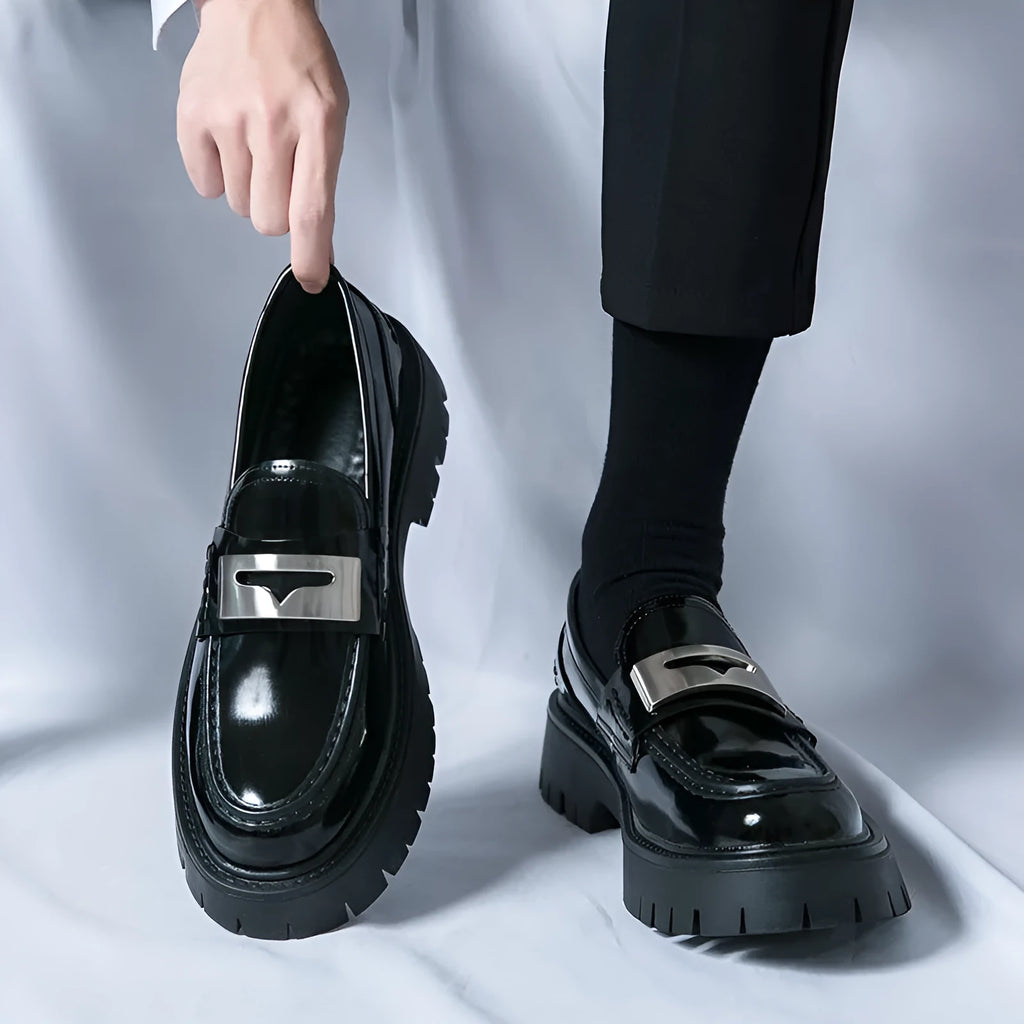 Men's black glossy PU leather loafers with a low platform sole, shown in a summer setting.