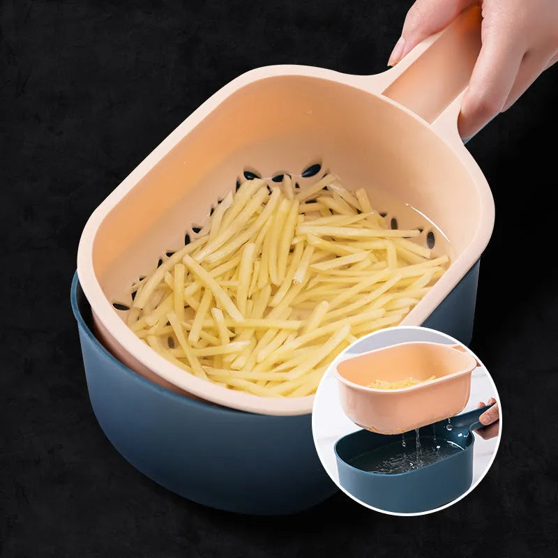 Dark blue vegetable cutter kitchen tool with hand guard, four stainless steel blades, and a white drain basket.