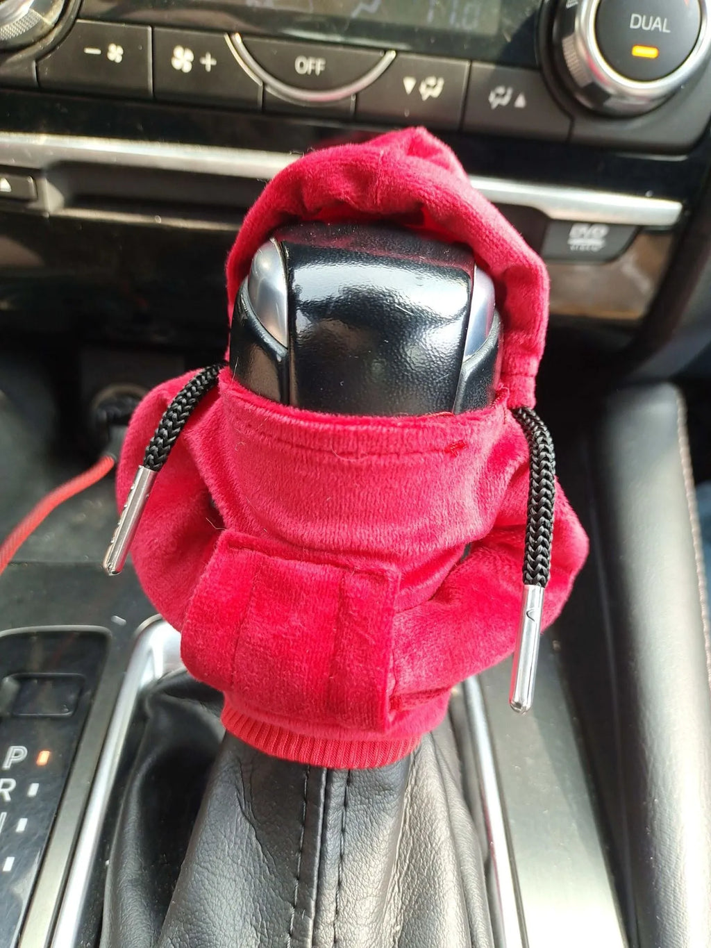 Hand-knitted red pure cotton gear lever sweater decoration on a car gear stick.
