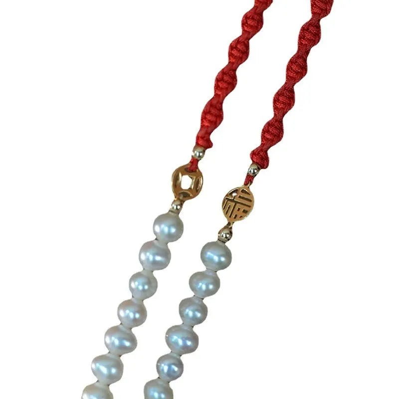 Women's pearl bracelet with braided red rope and gold plated fu character charm