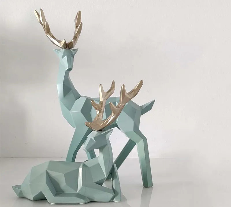 Set of three modern resin deer statues in graduated sizes on a shelf