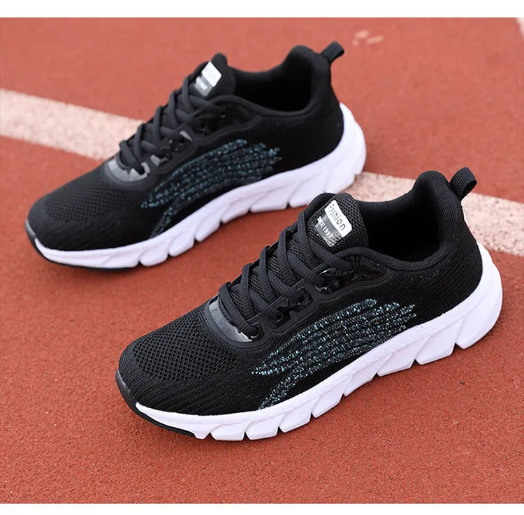Women's low-cut black and white casual running sneakers with cross-strap detail and a lightweight MD sole.