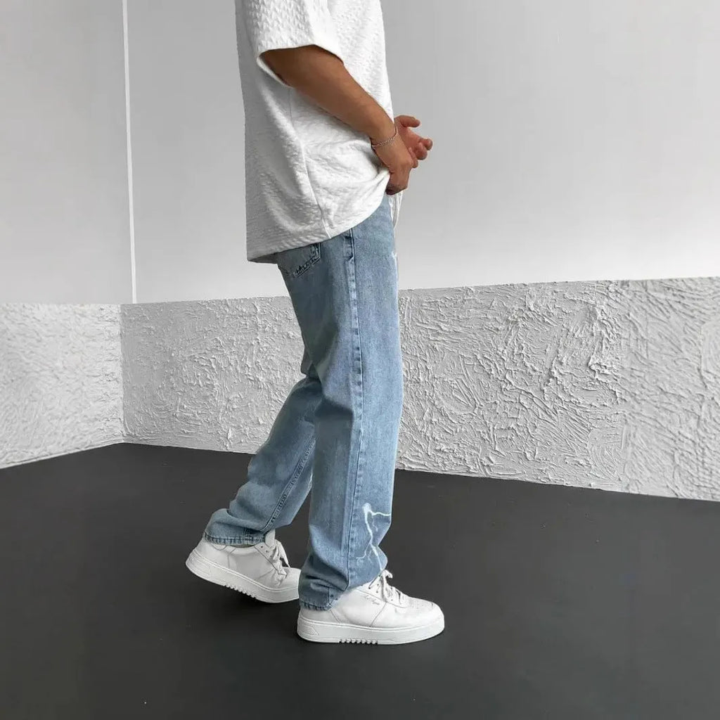 Men's blue straight-leg jeans with a loose wide-leg cut and printed design.