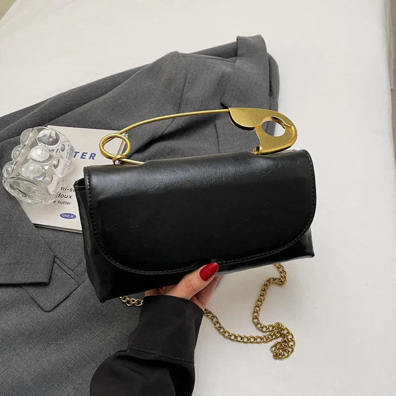 Black street trend shoulder handbag with sandwich pockets and visible sewing thread details.