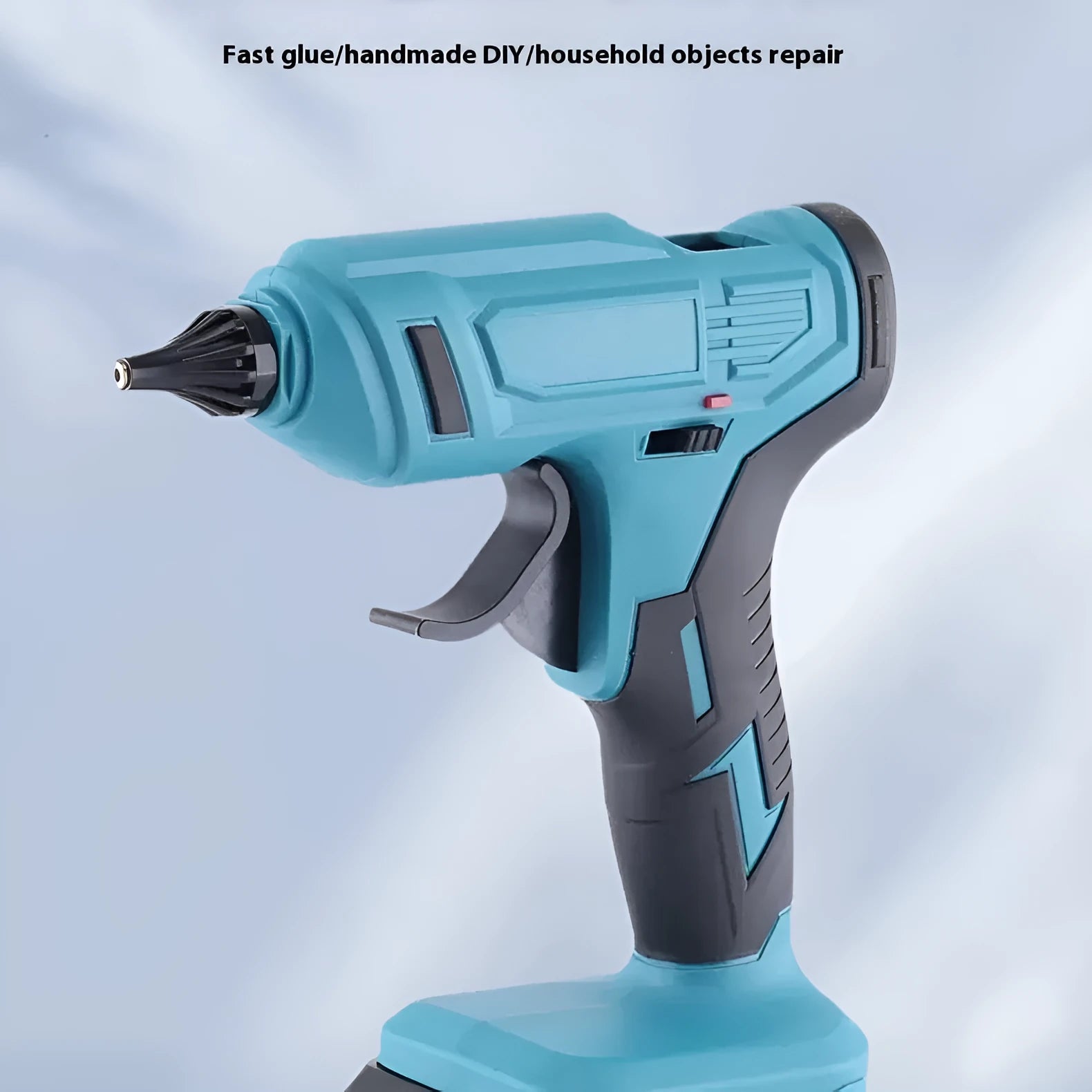 Cordless hot glue gun with two batteries, a charger, and a pack of glue sticks on a workbench.