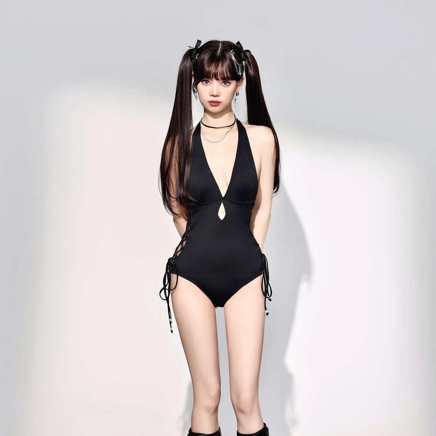 Black women's one-piece swimsuit with V-neck and hollow strap design on a mannequin