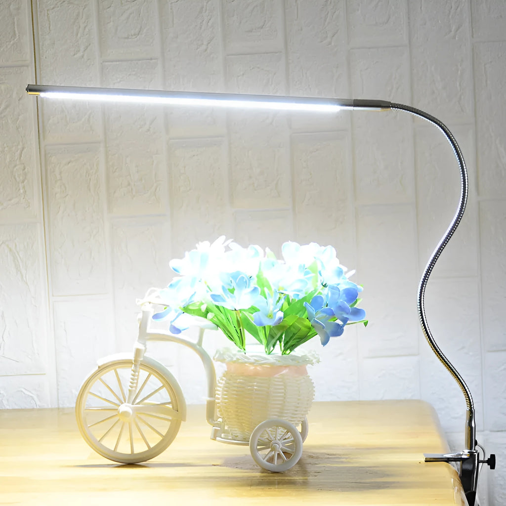 Silver aluminium alloy USB LED nail lamp with long arm and clip-on base, lit with bright white light.