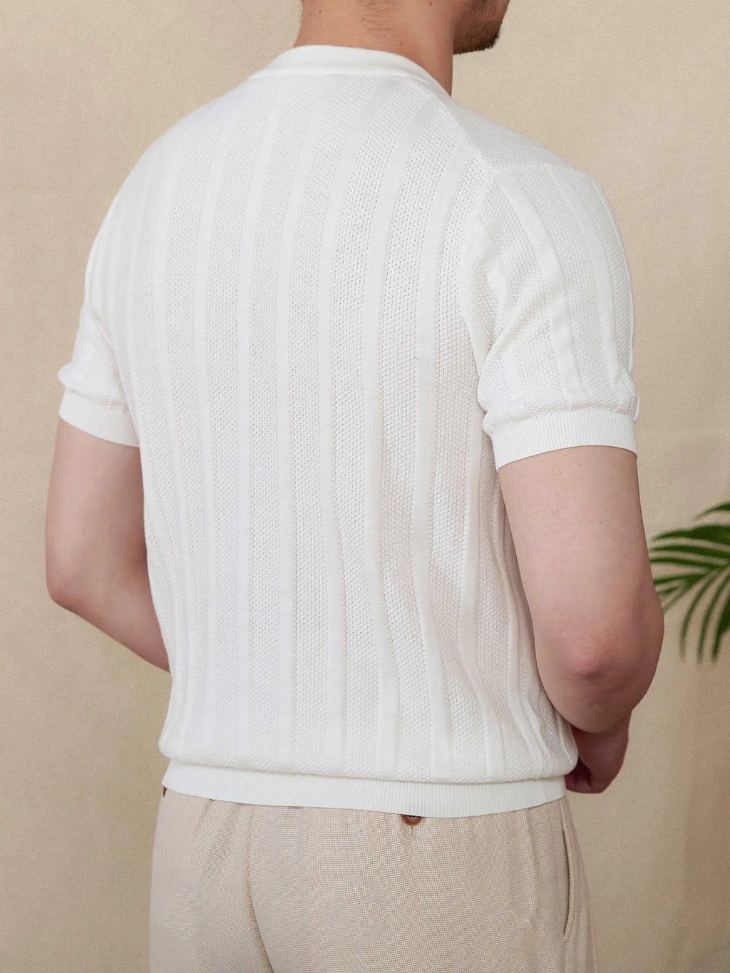 Men's beige cotton T-shirt with henry collar and subtle sunken stripe pattern on the front.