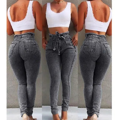 A pair of light blue fringed jeans with a distressed hem laid flat.