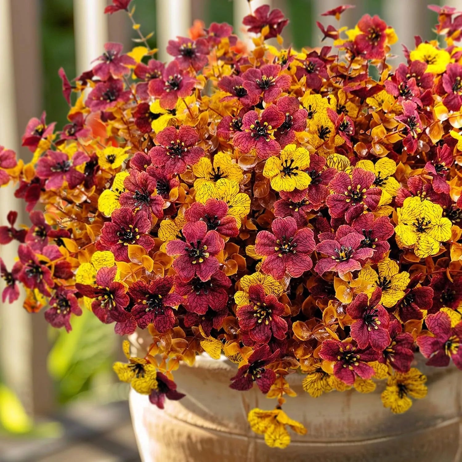 Artificial flower bouquet in autumn colours of red, yellow, and orange for home and event decoration.