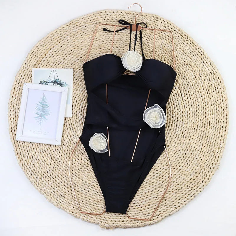 Women's black one-piece swimsuit with 3D floral detailing on the front.