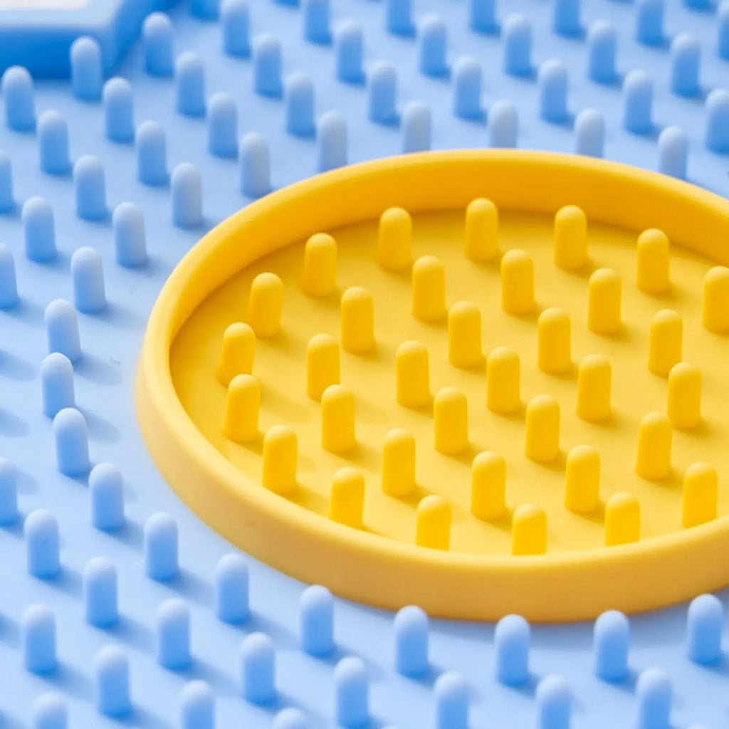 Flower-shaped silicone slow feeder licking mat for dogs and cats with suction cups on a smooth surface.