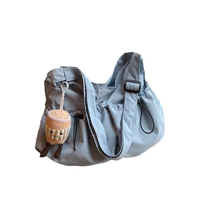Green pleated crossbody bag with split pocket, folded to show 1cm thickness and mobile phone compartment inside