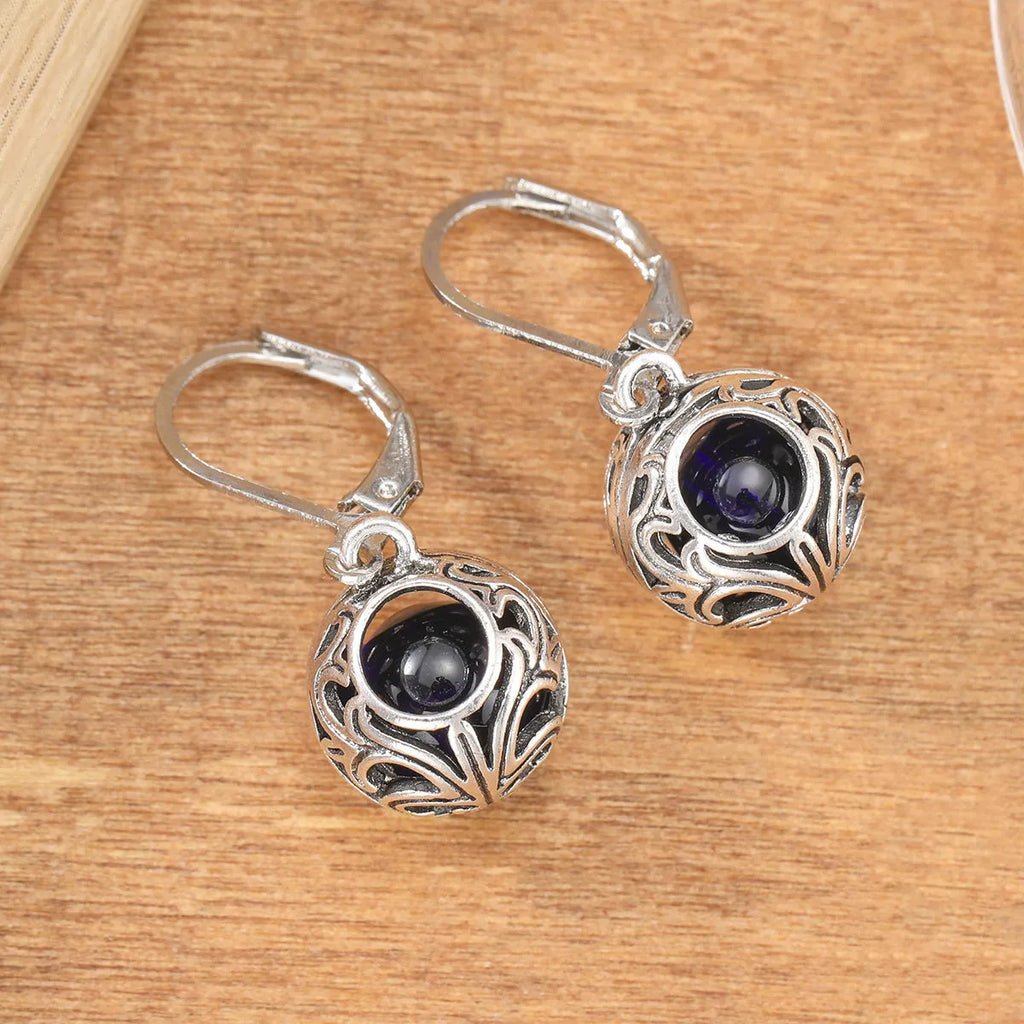 Silver geometric pendant earrings with vintage engraving and hollow design around blue gemstone