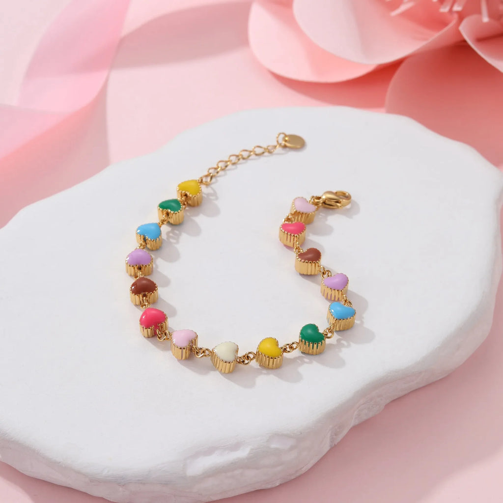 Gold and steel colour heart-shaped titanium steel bracelet on a model's wrist.