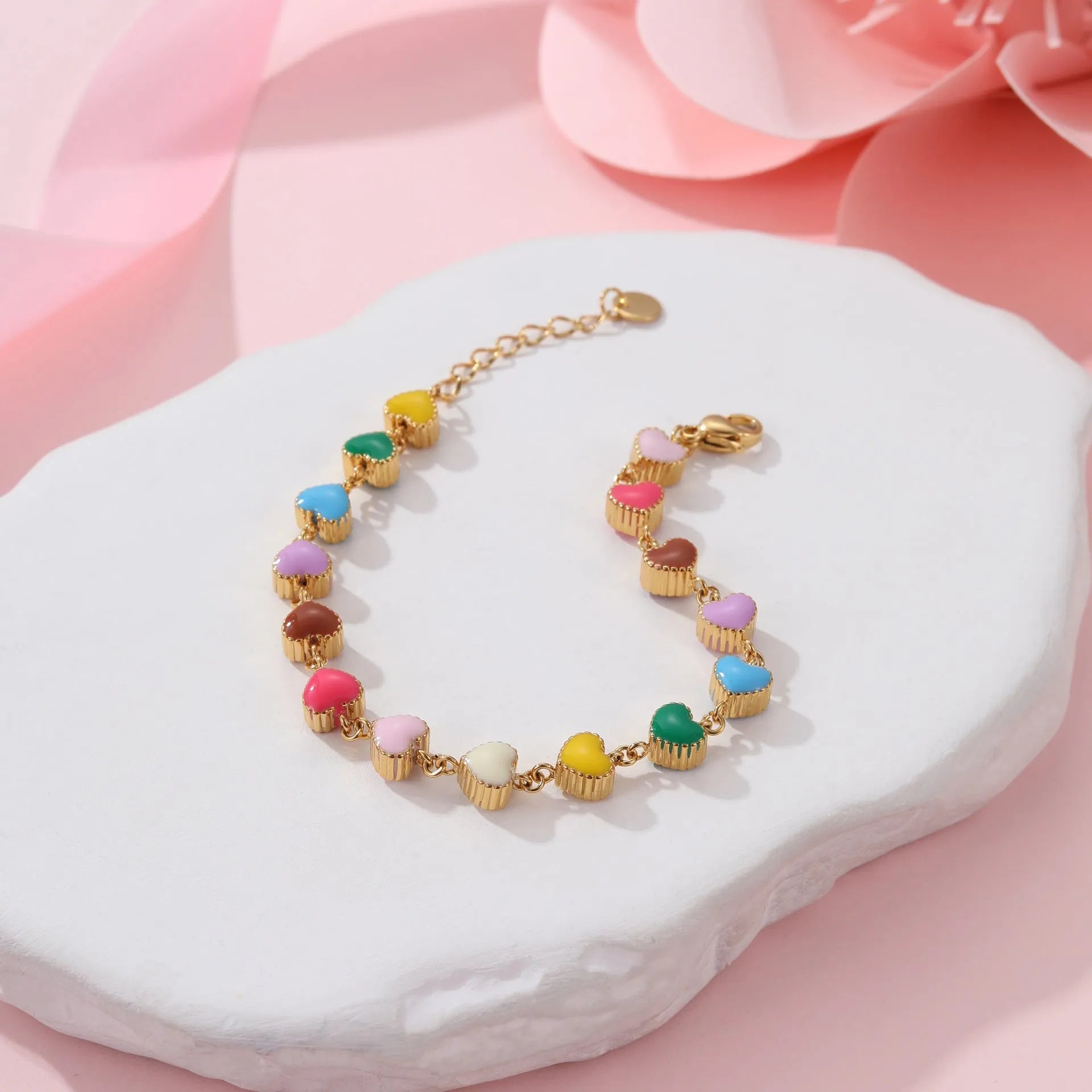 Gold and steel colour heart-shaped titanium steel bracelet on a model's wrist.