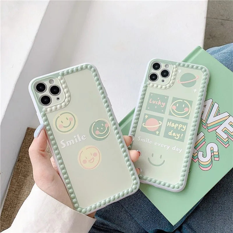 Green TPU iPhone case with geometric smiley face and polka dot frame designs on a table