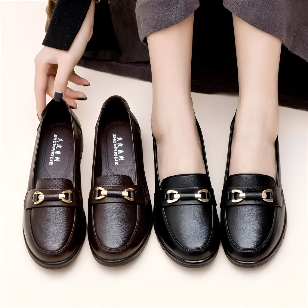 Black women's low-heel leather pumps with a round toe and soft rubber sole.