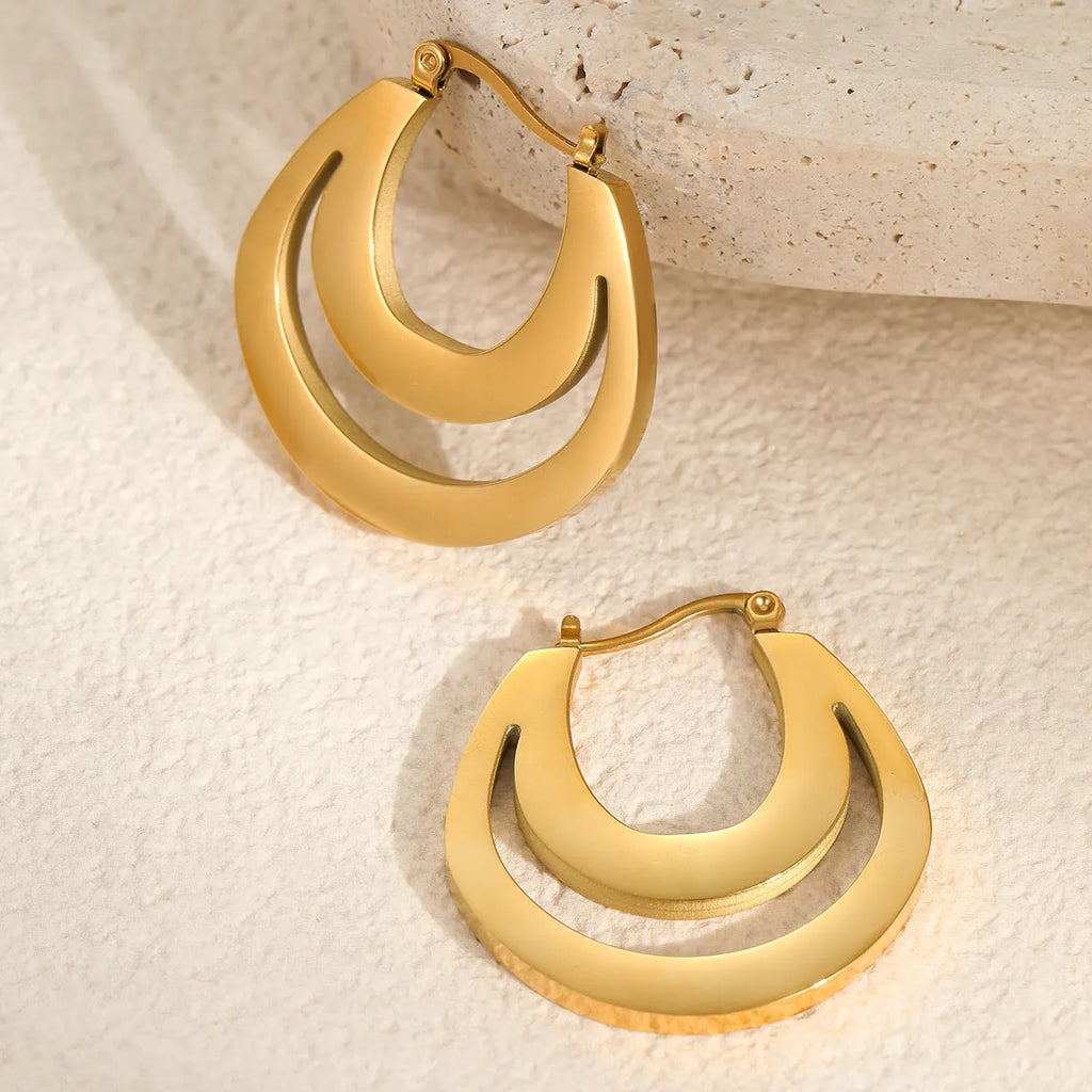 A pair of geometric minimalist French earrings in a round ring design, shown in both gold and steel metallic finishes.