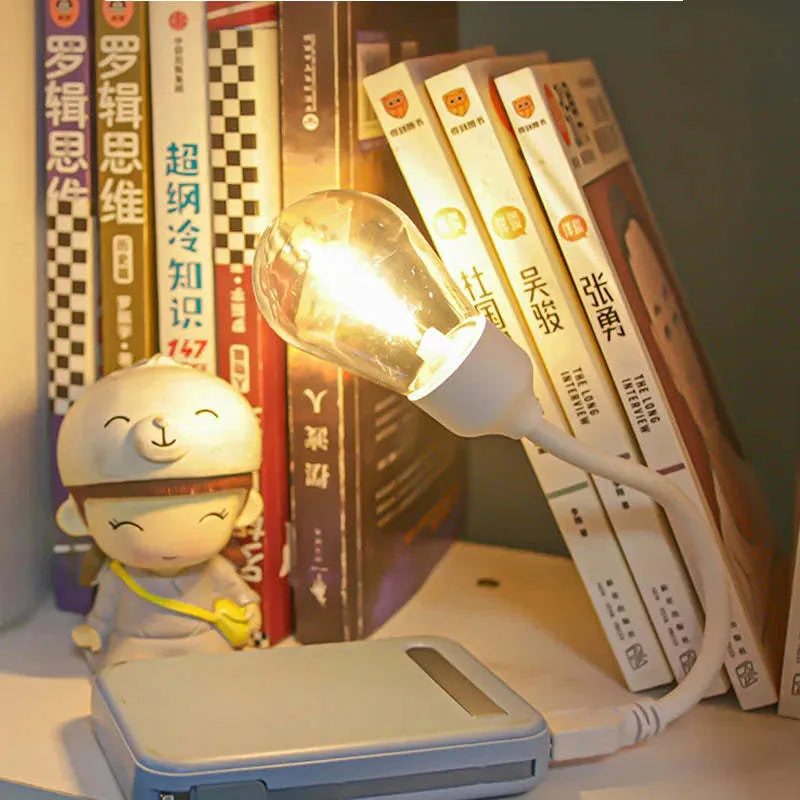 USB rechargeable folding tungsten night light with glowing S14 bulb on a table.
