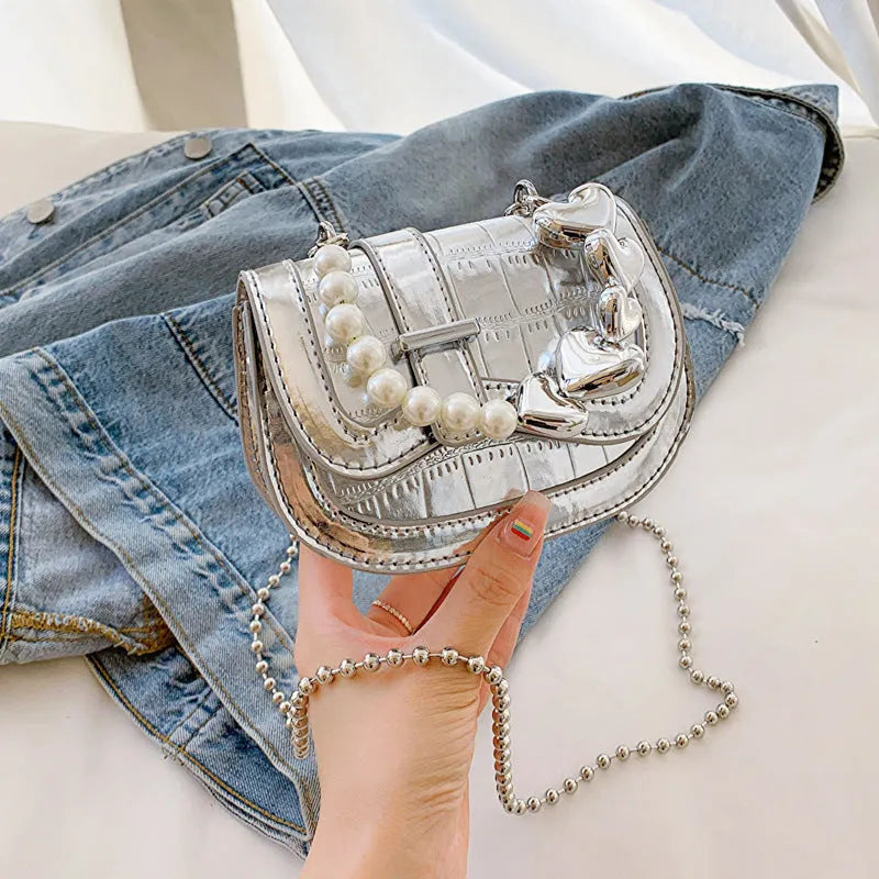 Laser Pearl Tote Saddle Girl Mini crossbody bag in gold colour showing horizontal square design and shoulder strap