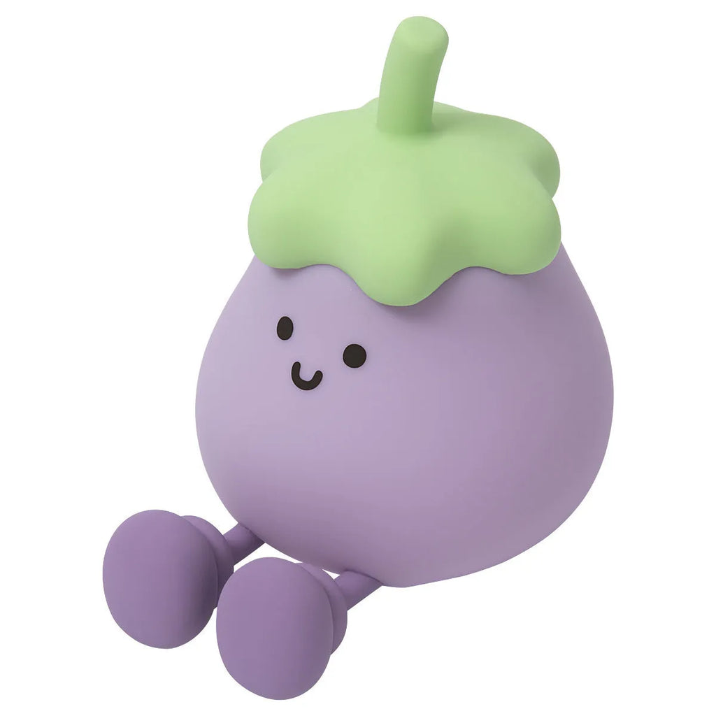 Cartoon-shaped eggplant night lamp glowing with soft yellow light on a table.