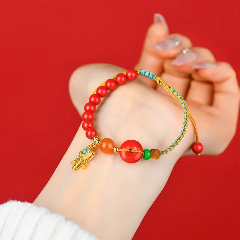 Hand-woven cinnabar bracelet with geometric peace blessing buckle in emperor red sand colour