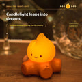 Silicone small fire pile cartoon night lamp with yellow light on wooden surface