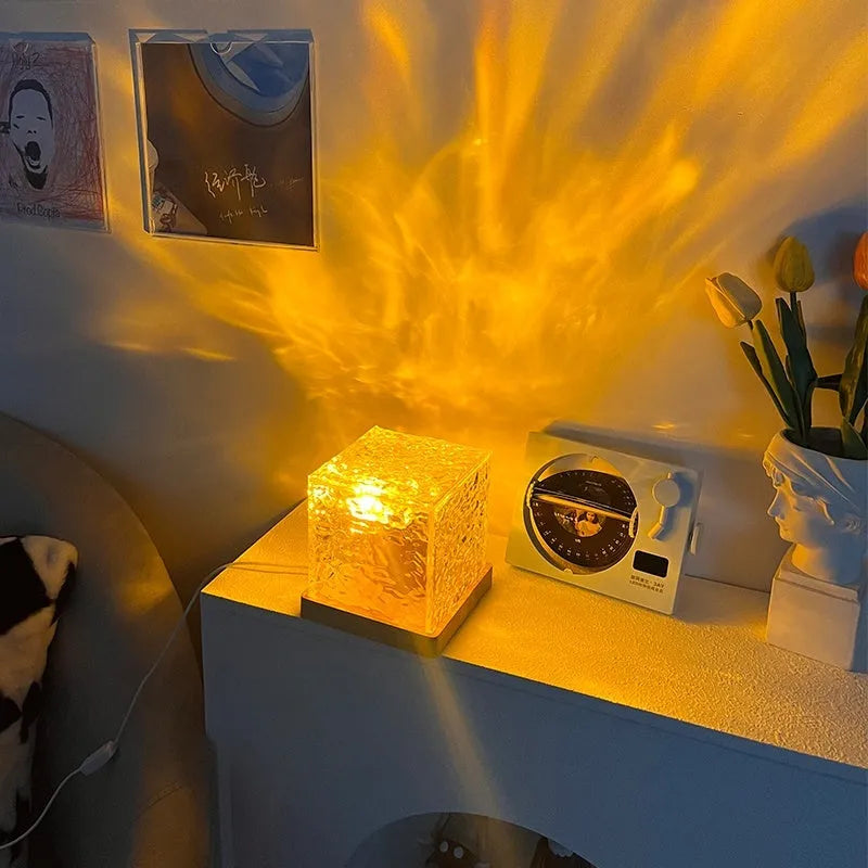 USB rechargeable LED water ripple night light with remote control on a table.