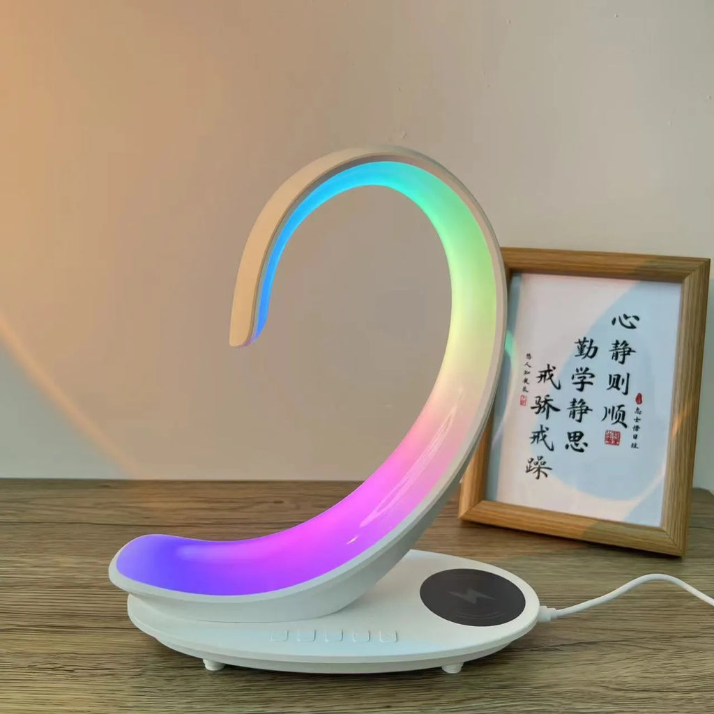 White swan shaped desktop device with colourful lighting, wireless charging pad, and Bluetooth speaker functions