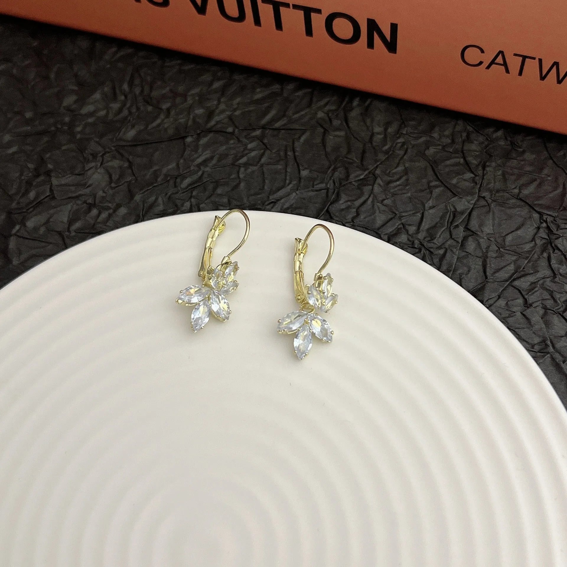 A pair of platinum-coloured alloy earrings in a leaf shape with an inlaid zircon shiny finish.