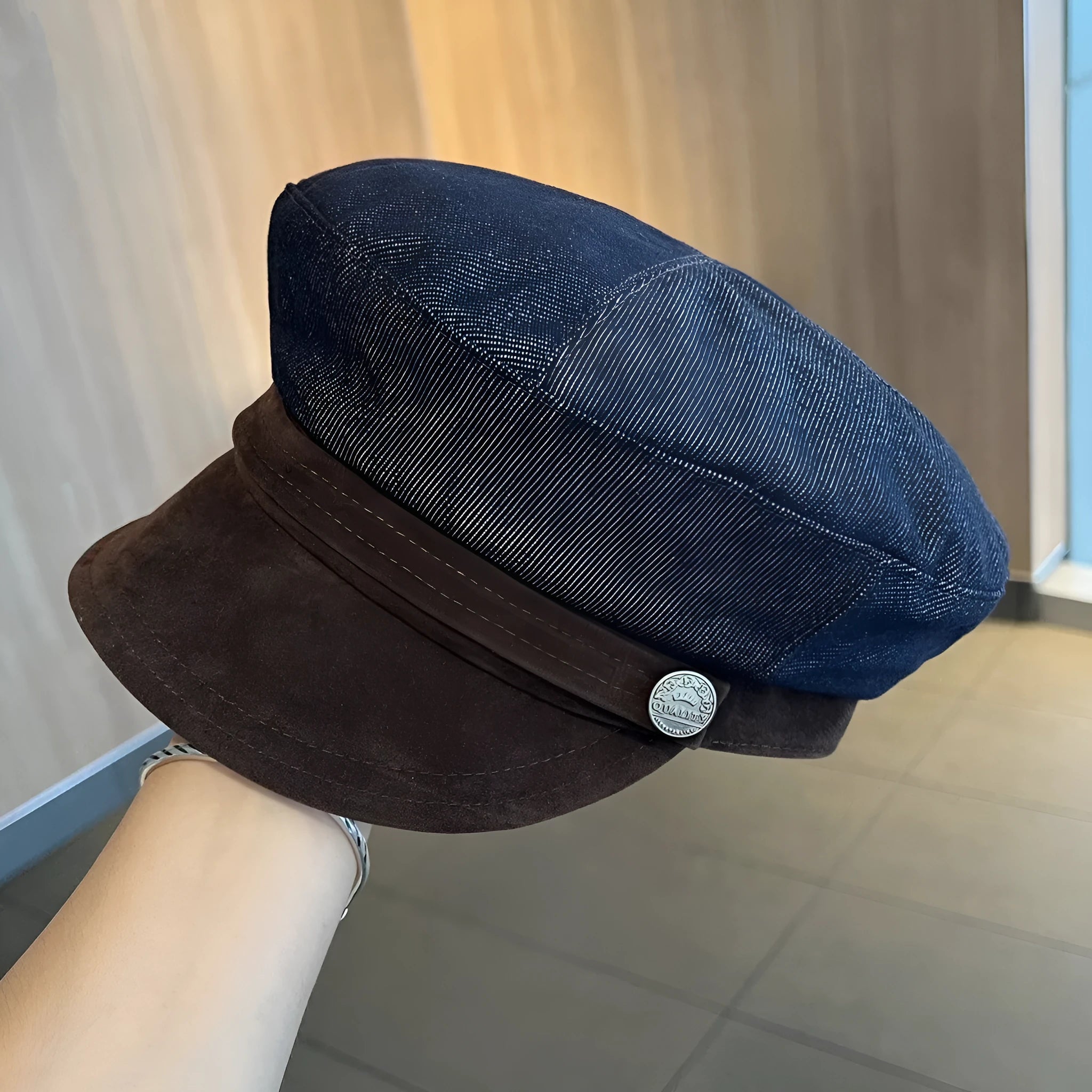 Dark blue denim British retro octagonal newsboy cap with an adjustable strap and coloured brim option on display.