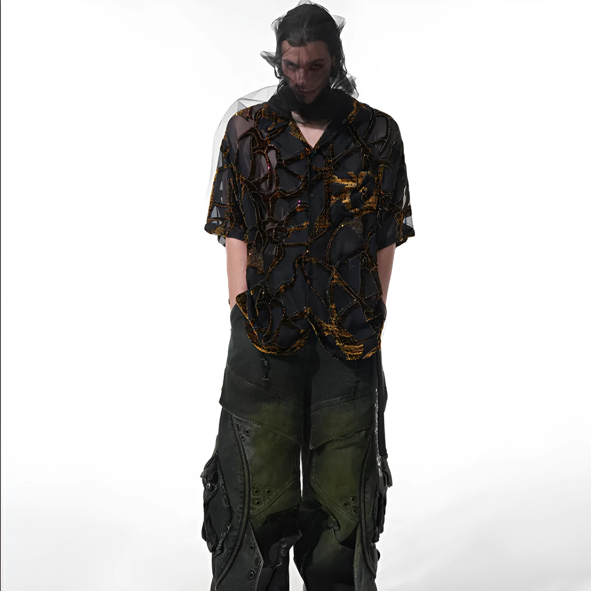 Man wearing a black translucent short-sleeved shirt with a snake pattern, featuring a lapel collar and loose fit.