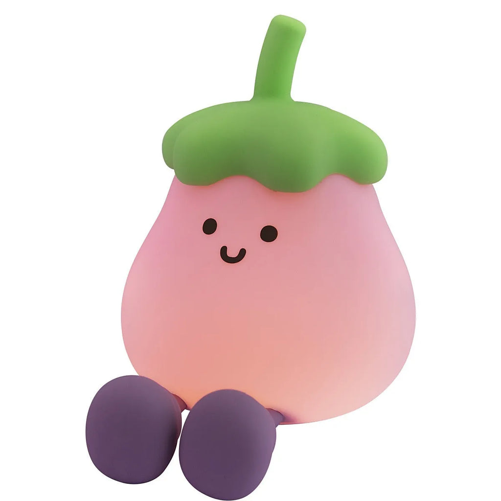 Cartoon-shaped eggplant night lamp glowing with soft yellow light on a table.
