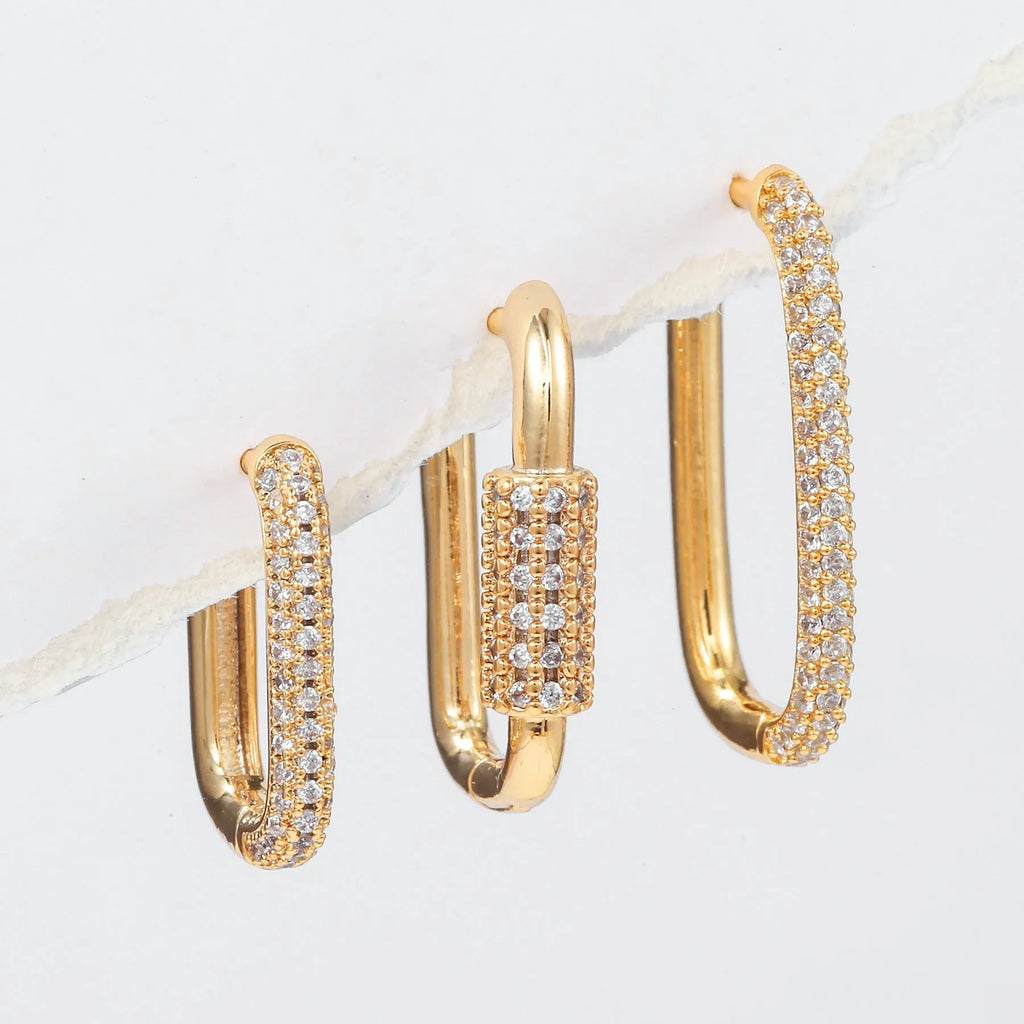 Three geometric copper ear clips with zircon detailing in ellipse and quadrilateral shapes on ear