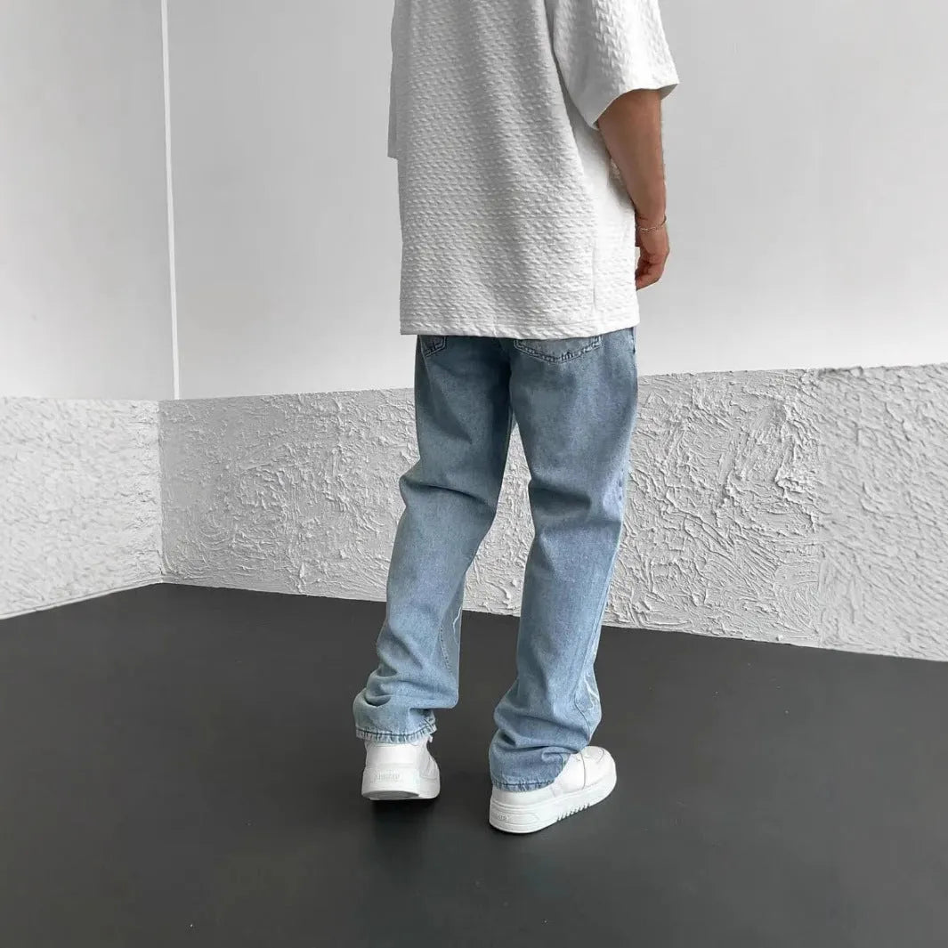 Men's blue straight-leg jeans with a loose wide-leg cut and printed design.