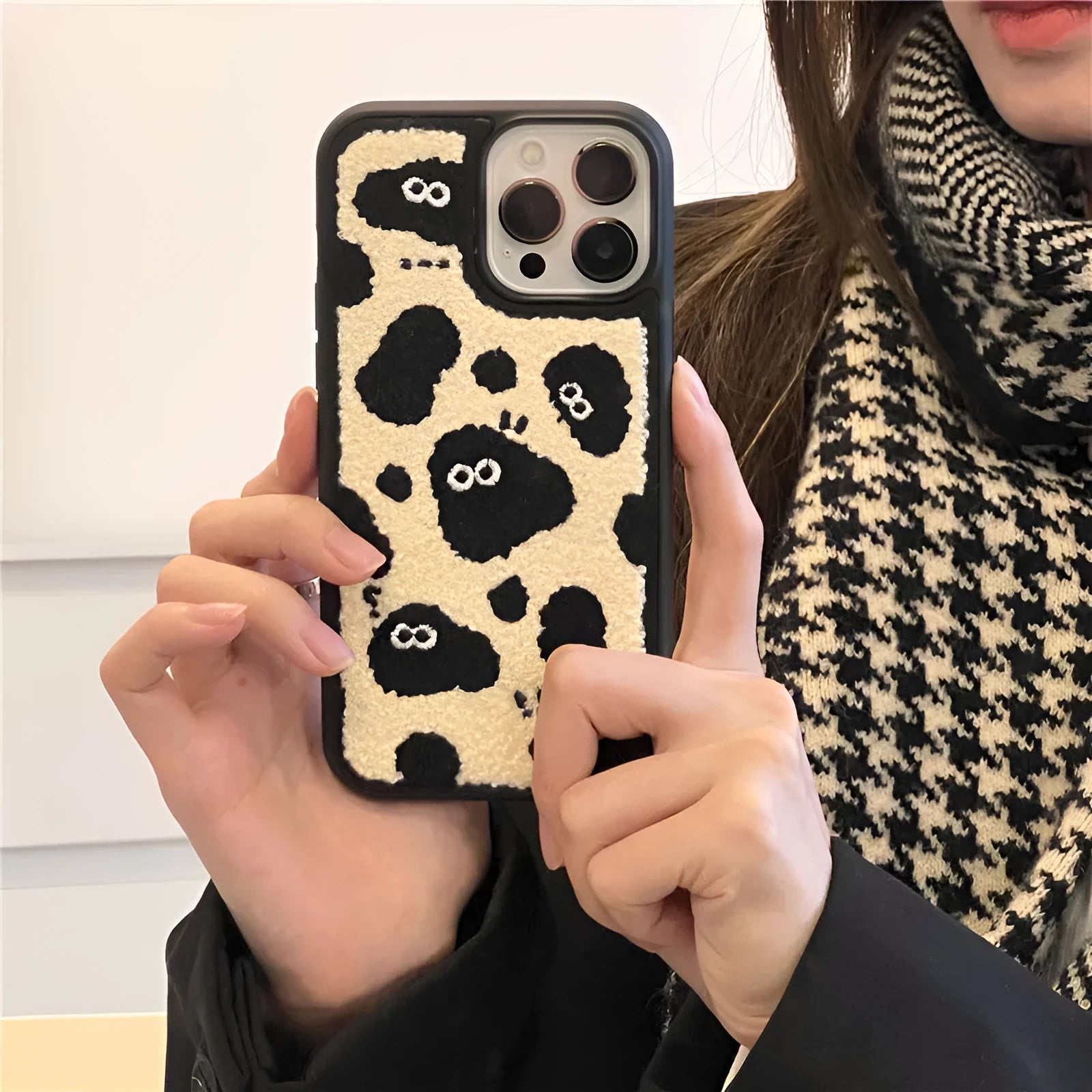 Black plush fairy-themed funny back cover case for iPhone on a table
