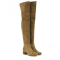 Women's grey suede over-the-knee boots with pointed toe and thick rubber sole on a wooden floor