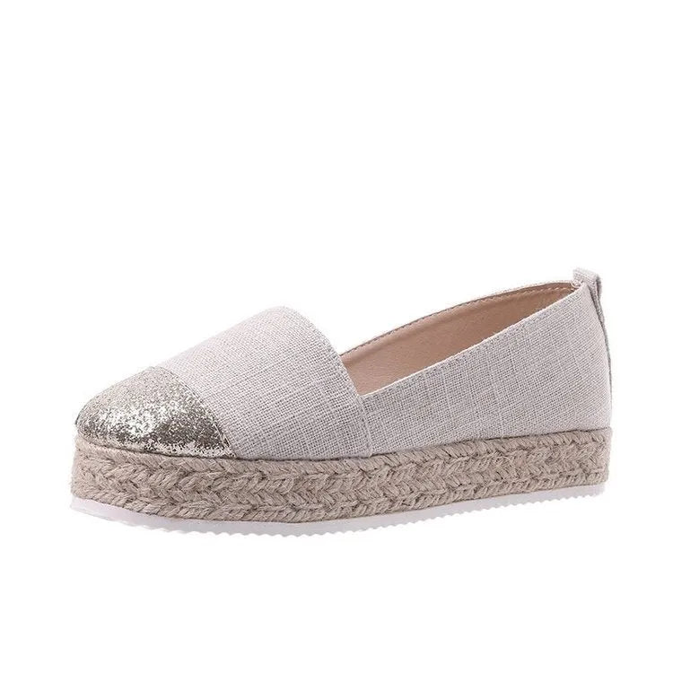 Beige and black canvas shoe covers with round toe design showing oversleeves construction