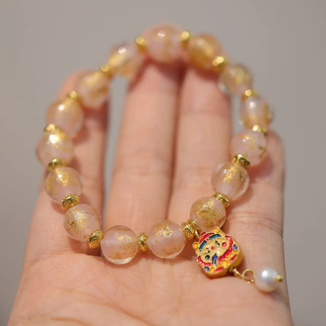 Gold foil coloured glaze ethnic bracelet with geometric design and God of Wealth pearl or porcelain hanging gourd