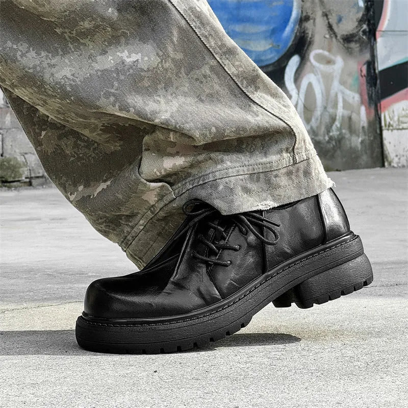 Black low-top platform leather shoes with round toe and rubber sole.